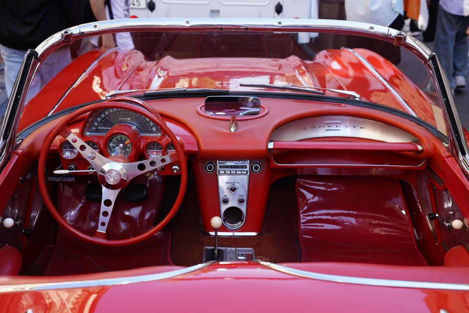 Detailed view of a classic red convertible car's interior and dashboard, showcasing retro design.